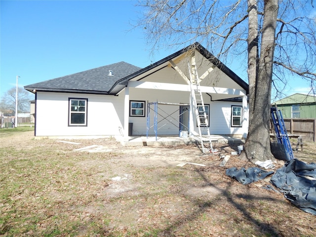 back of house with roof with shingles