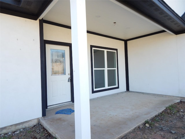 entrance to property with a patio area and stucco siding