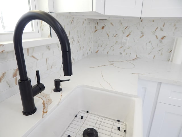 interior details featuring light stone counters and white cabinets