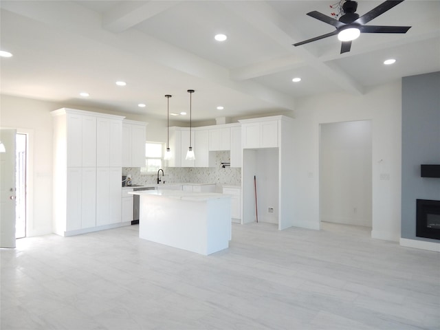 kitchen featuring a kitchen island, white cabinetry, light countertops, and pendant lighting