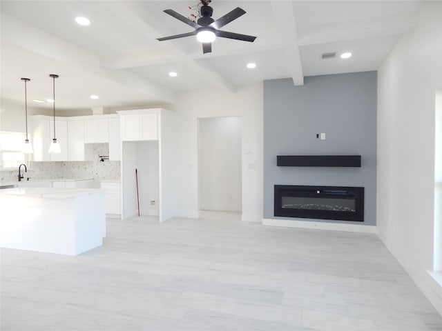 kitchen with visible vents, open floor plan, white cabinetry, pendant lighting, and backsplash