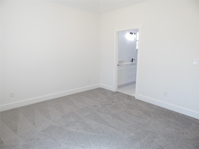 empty room featuring baseboards and light colored carpet