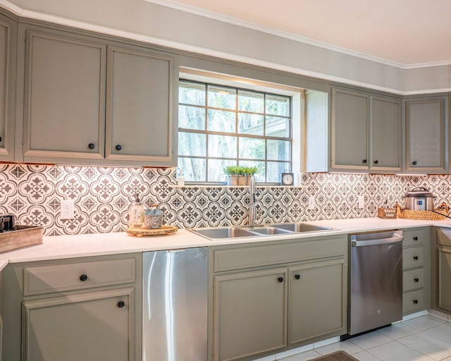 kitchen with appliances with stainless steel finishes, light tile patterned floors, decorative backsplash, sink, and ornamental molding