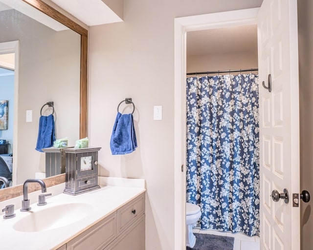 bathroom featuring curtained shower, toilet, vanity, and tile patterned flooring