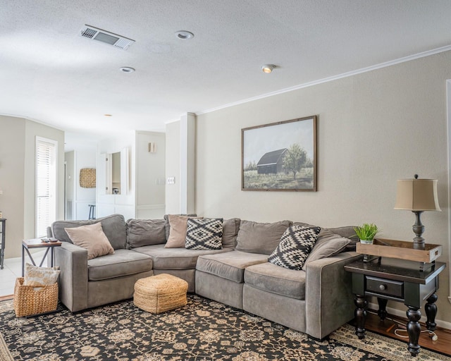 living room with hardwood / wood-style flooring, a textured ceiling, and ornamental molding