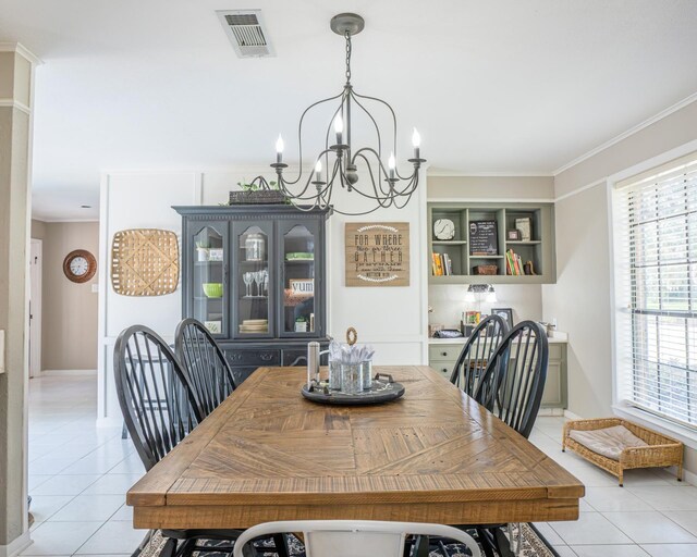 dining space featuring a wealth of natural light, light tile patterned floors, crown molding, and an inviting chandelier