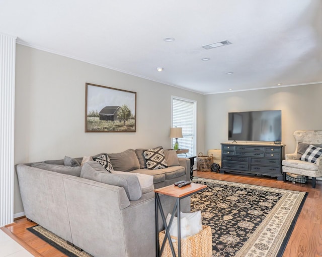 living room with light hardwood / wood-style flooring and crown molding