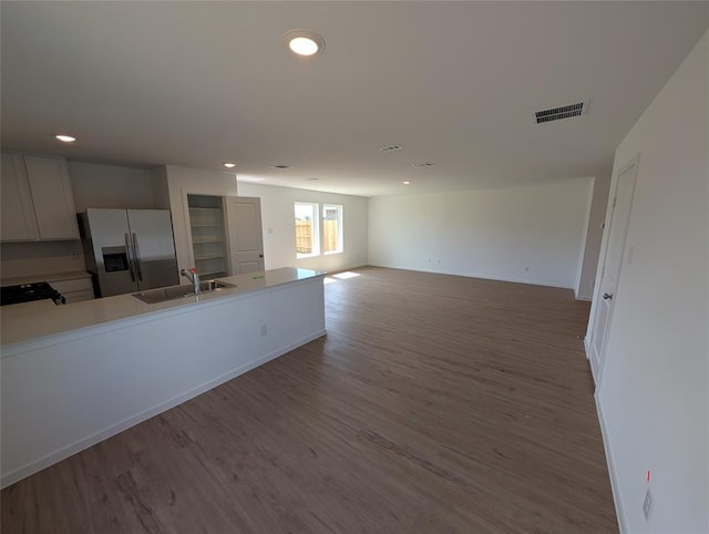 kitchen featuring hardwood / wood-style flooring, sink, white cabinetry, and stainless steel fridge with ice dispenser