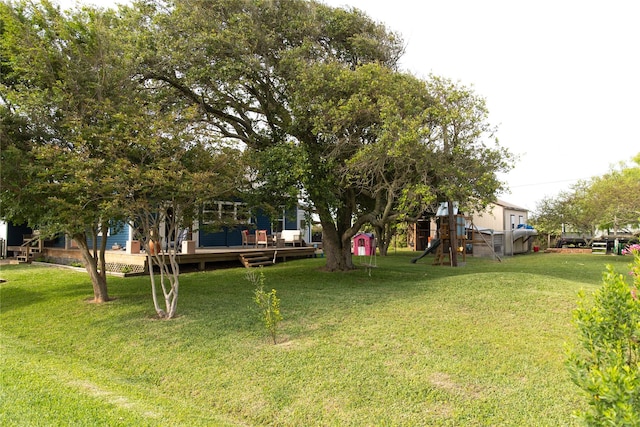 view of yard with a wooden deck and a playground