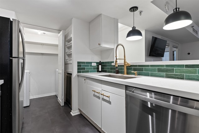 kitchen with sink, hanging light fixtures, white cabinets, and stainless steel appliances