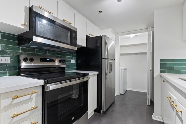 kitchen with white cabinets, backsplash, light stone countertops, and appliances with stainless steel finishes