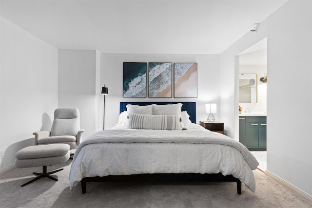 carpeted bedroom featuring sink and ensuite bath