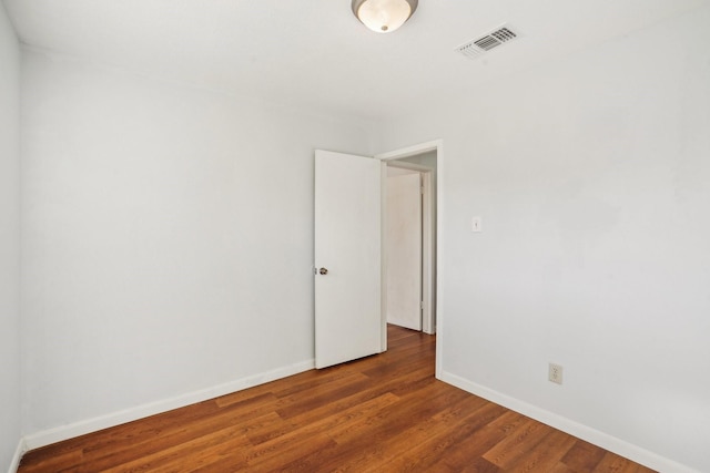 empty room with dark hardwood / wood-style flooring