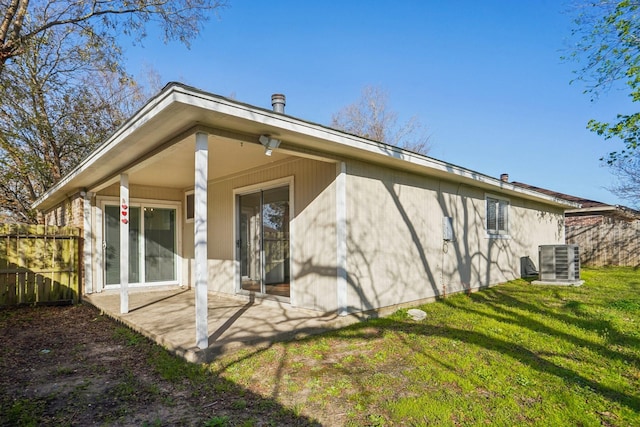 back of property featuring central AC unit and a lawn