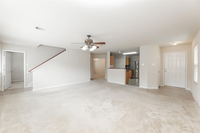 unfurnished living room featuring light carpet and ceiling fan