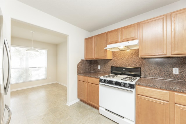 kitchen featuring light brown cabinetry, stainless steel refrigerator, white range with gas cooktop, decorative light fixtures, and backsplash