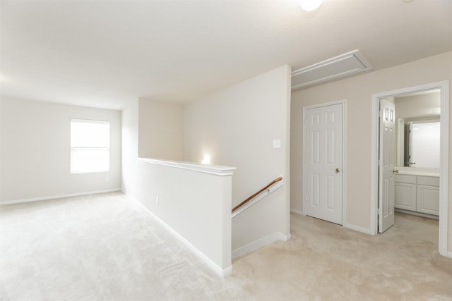 hallway featuring light colored carpet