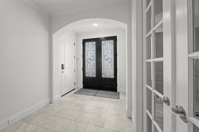 entryway featuring crown molding and french doors