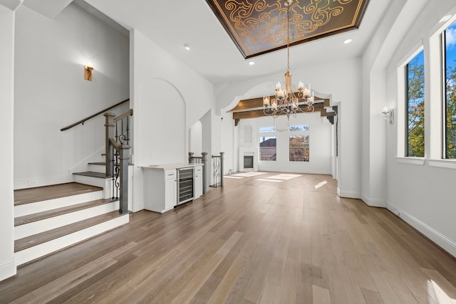 interior space featuring wine cooler, light hardwood / wood-style flooring, and a chandelier