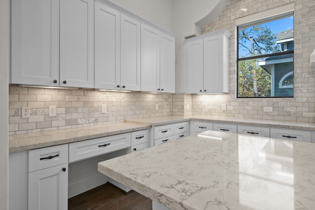 kitchen featuring white cabinetry, light stone counters, and decorative backsplash