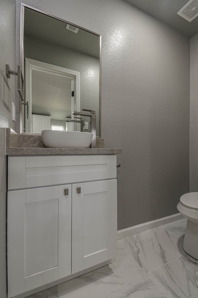 bathroom featuring vanity and toilet