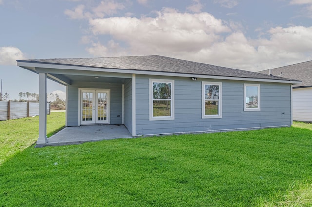 rear view of house featuring a patio area, a lawn, and french doors