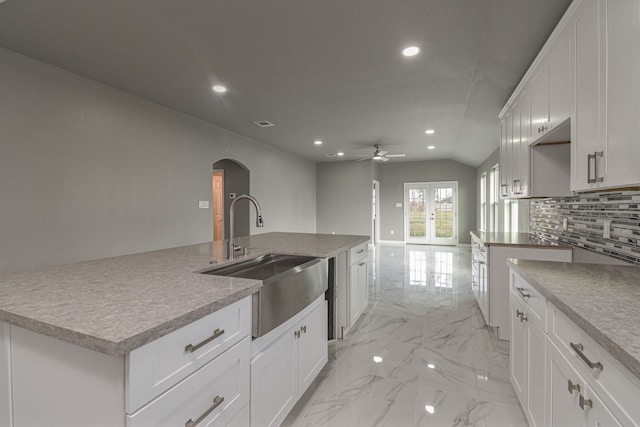 kitchen with sink, white cabinetry, and a center island with sink