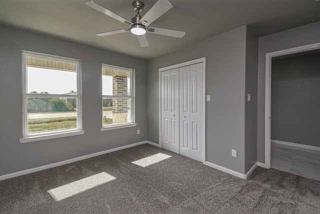 unfurnished bedroom featuring ceiling fan, a closet, and carpet floors