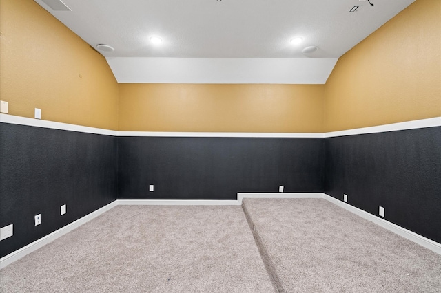 carpeted empty room with lofted ceiling