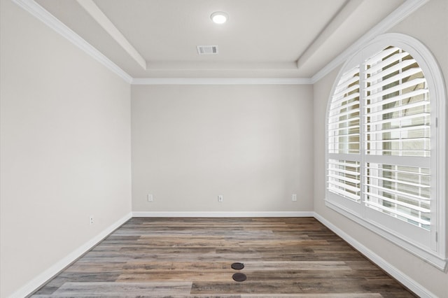 spare room with dark hardwood / wood-style floors, ornamental molding, and a raised ceiling