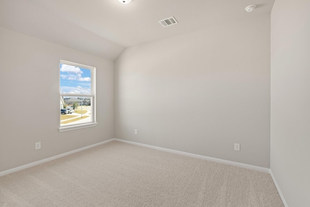 empty room with vaulted ceiling and carpet flooring