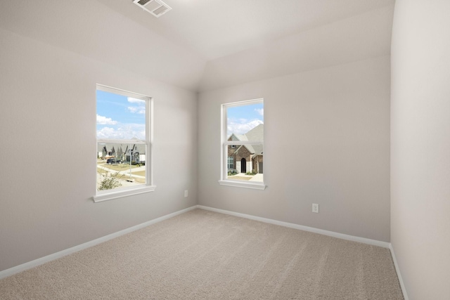 carpeted spare room featuring lofted ceiling