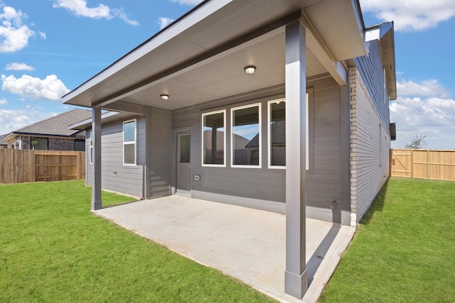 rear view of house featuring a patio area and a lawn