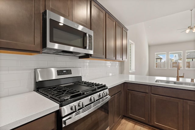 kitchen with sink, dark brown cabinets, backsplash, and stainless steel appliances