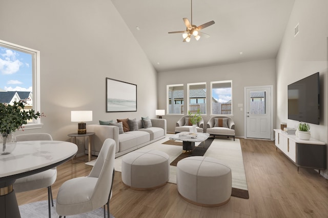 living room with high vaulted ceiling, light hardwood / wood-style floors, and a wealth of natural light