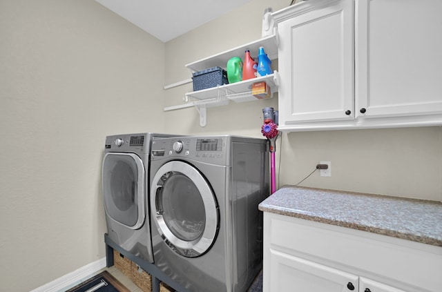 washroom with cabinets and washing machine and clothes dryer