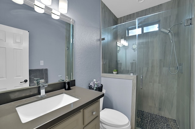 bathroom featuring vanity, toilet, and a shower with shower door