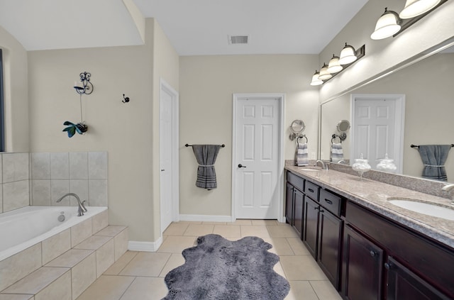 bathroom with vanity, tile patterned floors, and tiled bath