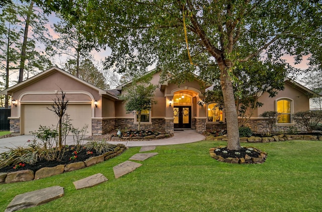 view of front of property with french doors, a garage, and a yard