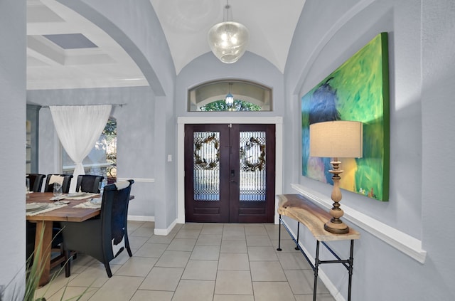 foyer featuring lofted ceiling, light tile patterned floors, and french doors