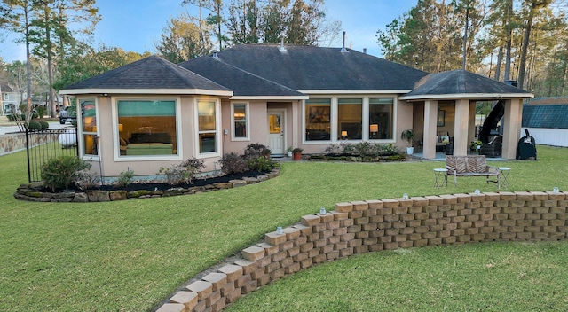 back of house featuring a lawn