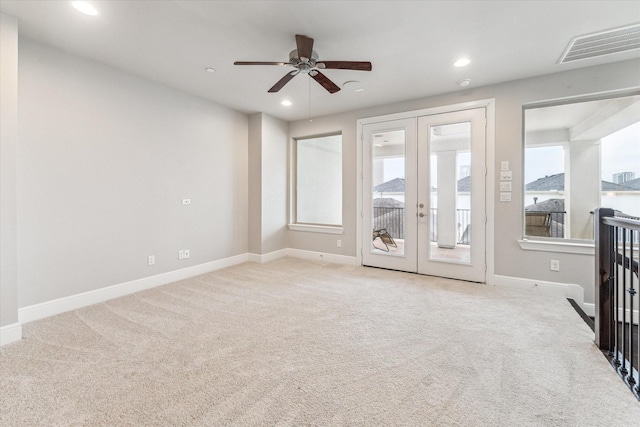 carpeted empty room with french doors and ceiling fan