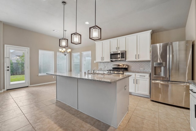 kitchen featuring hanging light fixtures, a kitchen island with sink, white cabinetry, and stainless steel appliances