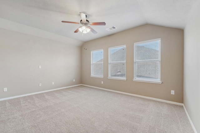 spare room featuring ceiling fan, light carpet, and lofted ceiling