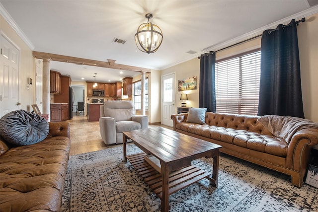 living room featuring crown molding, a wealth of natural light, decorative columns, and light wood-type flooring