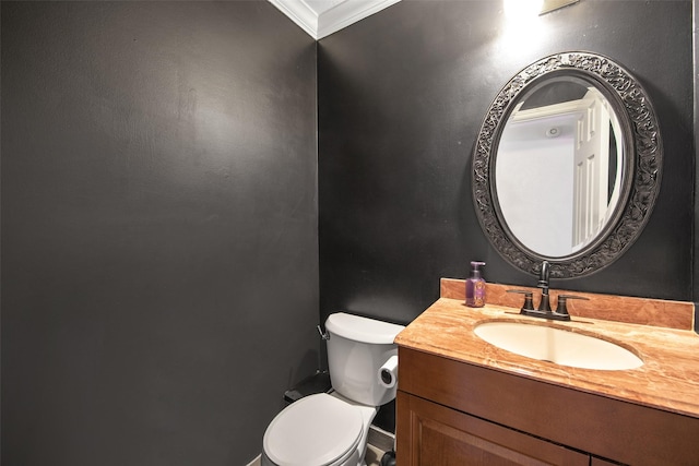 bathroom with vanity, crown molding, and toilet