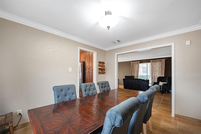 dining room featuring ornamental molding and tile patterned flooring