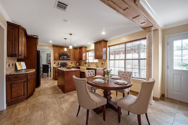 dining space with crown molding, a healthy amount of sunlight, sink, and decorative columns