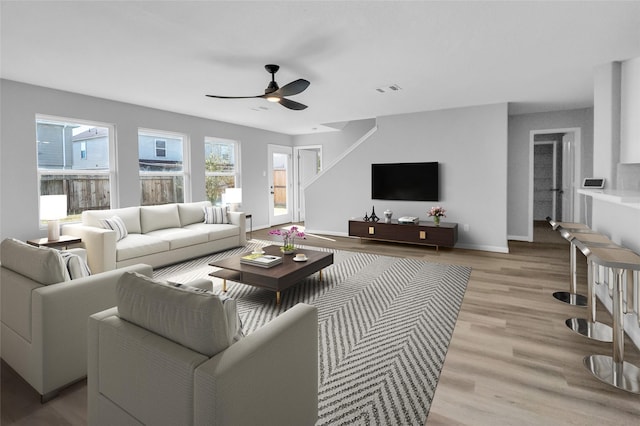 living room featuring light hardwood / wood-style floors and ceiling fan