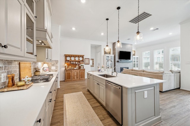 kitchen featuring sink, white cabinets, a center island with sink, and stainless steel appliances